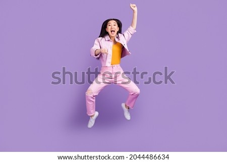 Full body photo of hooray millennial brunette lady jump wear jacket jeans sneakers isolated on violet background
