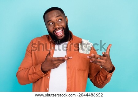 Photo of young afro man happy positive smile rich businessman cash money dollars look empty space isolated over teal color background