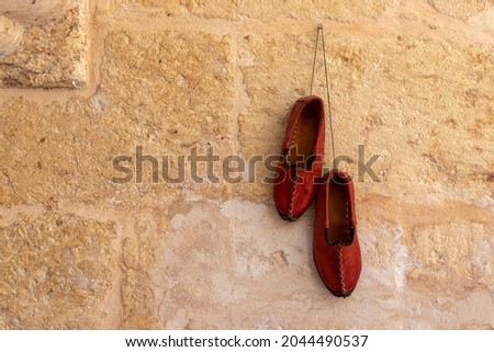 Traditional turkish handmade shoes Yemeni hanging on the wall. Gaziantep, Turkey. Royalty-Free Stock Photo #2044490537