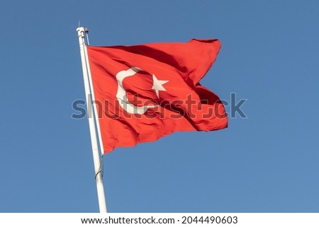 Waving flag of Turkey on a background of blue sky.