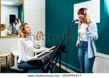 Vocal coach training her student's voice on a lesson Royalty-Free Stock Photo #2044494557