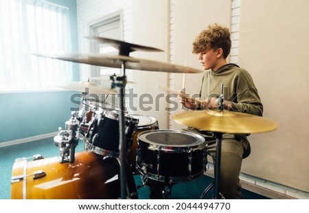 Young teen boy practicing drumming. Drum music school. Royalty-Free Stock Photo #2044494770