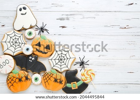 Halloween gingerbread cookies with spiders on white wooden table