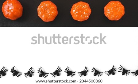 Halloween holiday. Flatly on a black and white background. Copyspace. Spiders and pumpkins in a row.
