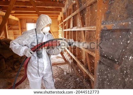Spraying cellulose insulation on the wall Royalty-Free Stock Photo #2044512773