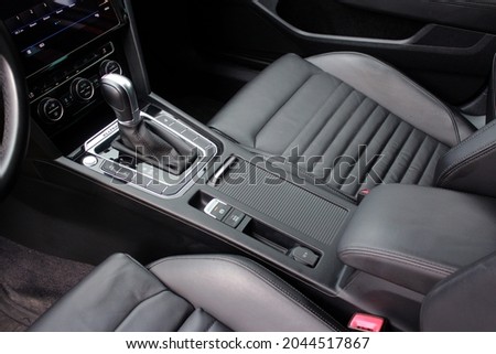 Car inside, automatic transmission close up, cup holders and armrest, black seats Royalty-Free Stock Photo #2044517867