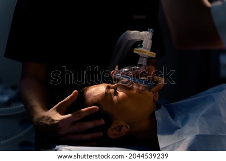 The doctor puts on a mask for artificial ventilation of the lungs in the intensive care unit. Royalty-Free Stock Photo #2044539239