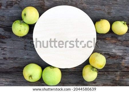 Wood round sign and delicious juicy green apples on rustic wooden table view from above. Template for creative design