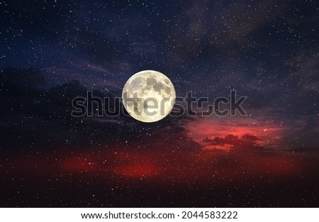 big moon on dramatic clouds  night starry sky at blue  orange dark  cosmic universe 