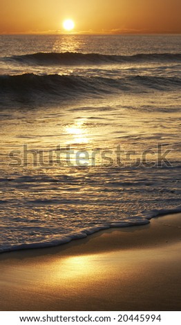 a picture of the sun falling on sand and water
