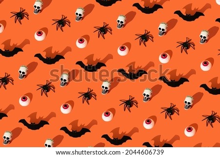 Creative idea made of bat, spider, skull and eye on orange background. Halloween concept.
