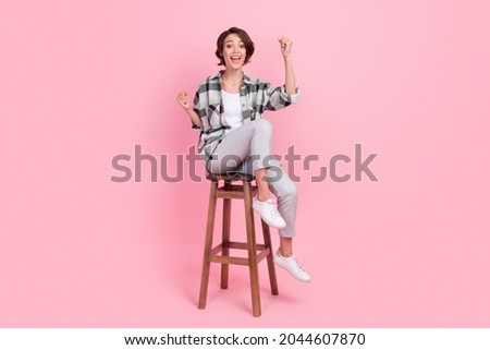 Full body photo of cool millennial brunette lady sit wear shirt trousers isolated on pink background Royalty-Free Stock Photo #2044607870