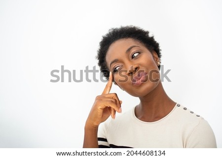 Close up portrait young African American woman thinking with finger to head by white isolated background 
