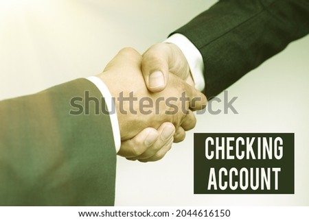 Text caption presenting Checking Account. Conceptual photo bank account that allows you easy access to your money Two Professional Well-Dressed Corporate Businessmen Handshake Indoors