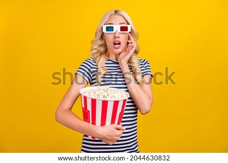 Photo portrait woman in casual clothes staring in 3d glasses eating pop corn watching horror isolated vivid yellow color background