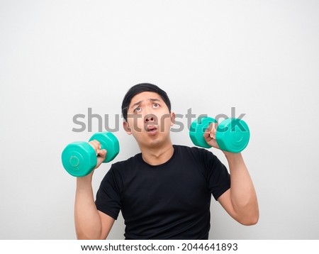 Asian man holding drumbbell feeling amazed and looking up copy space white background