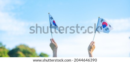 hand holding Korea flag on nature background. National Foundation, Gaecheonjeol, public Nation holiday, National Liberation Day of Korea and happy celebration concepts Royalty-Free Stock Photo #2044646390