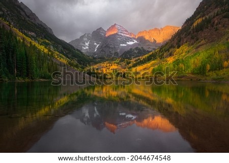 Fall color of aspen forest at Maroon Bells, Colorado. Beautiful sunrise with reflection lake. Royalty-Free Stock Photo #2044674548