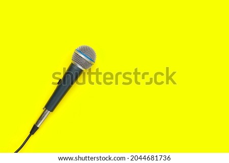 Microphone on yellow background. Top view