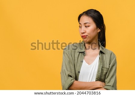 Portrait of young Asia lady with negative expression, excited screaming, crying emotional angry in casual clothing isolated on yellow background with blank copy space. Facial expression concept. Royalty-Free Stock Photo #2044703816