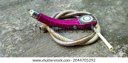 The handle and the purple shower hose are broken, dirty, crusty and rusty