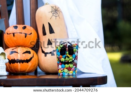 Decoration for Halloween. Pumpkins with creepy faces, colorful candies and sweets.