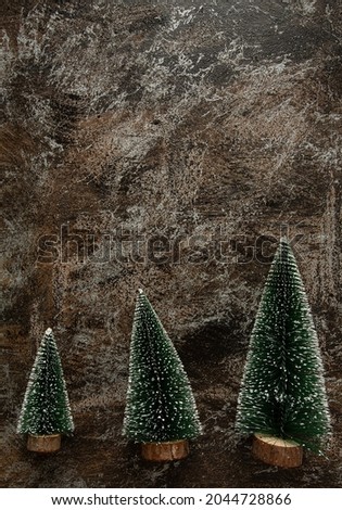 decorative Christmas trees on dark stone surface