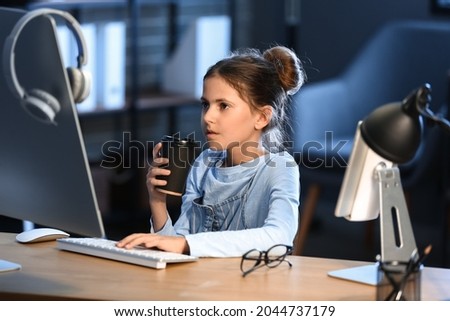 Little programmer with cup of coffee in office at night