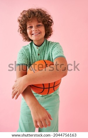 Caucasian teen basketball player posing confident isolated on pink background