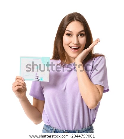 Surprised young woman with gift certificate for massage on white background