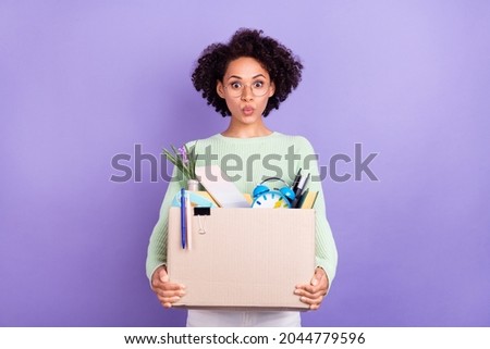 Photo of young amazed dark skin shocked woman hold hands box college move isolated on violet color background