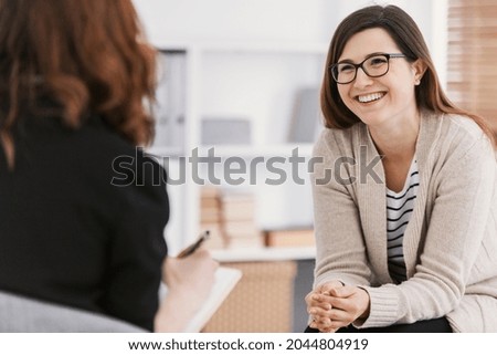 Happy woman during successful psychotherapy with counselor at clinic Royalty-Free Stock Photo #2044804919