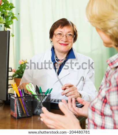Friendly mature doctor consulting female patient 