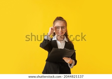 Cute little businesswoman with clipboard on color background Royalty-Free Stock Photo #2044821137