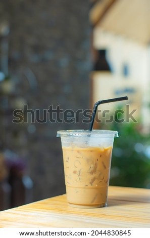 Iced Coffee in glass on the wooden table Background blurry.