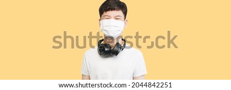 Back to school Teenager and kids Covid 19 vaccination banner. Portrait of a healthy smart and cool asian young boy with face mask smiling and feel confident after vaccinated. mRNA, Health pass, Yellow