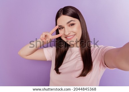 Portrait of pretty positive nice attractive lady take selfie show v-sign cover eye on purple background