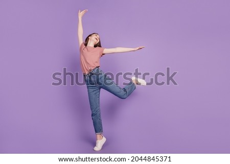 Cheerful young woman girl posing dancing isolated on violet background