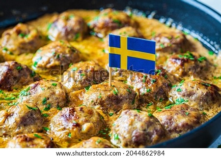 Swedish meatballs in a creamy sauce in a black frying pan, gray background, close-up. Scandinavian food concept. Royalty-Free Stock Photo #2044862984