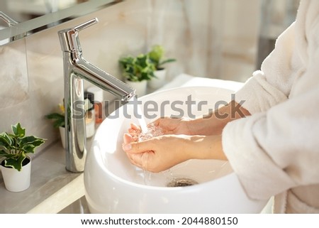 Close-up. Hand washing. bright bathroom, modern interior. dressing gown. Home hygiene. High quality photo Royalty-Free Stock Photo #2044880150