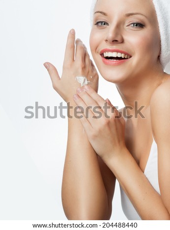 closeup portrait of attractive  caucasian smiling woman blond isolated on white studio shot lips toothy smile face applying cream head and shoulders looking at camera blue eyes tooth