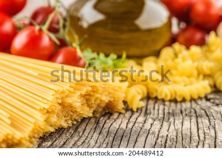 Spaghetti and tomatoes with olives oil on vintage wooden table Spaghetti