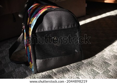 black cat in soft pet carrying bag on floor Royalty-Free Stock Photo #2044898219