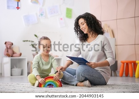 Female psychologist working with little girl at home Royalty-Free Stock Photo #2044903145