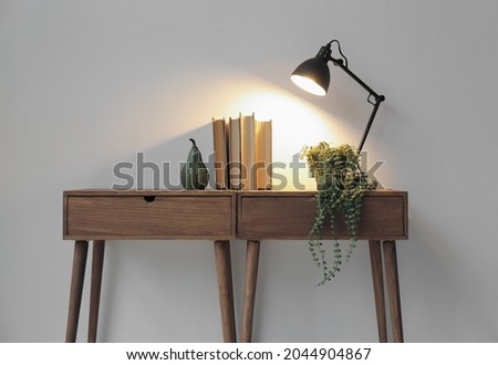 Tables with old books and lamp near light wall, closeup Royalty-Free Stock Photo #2044904867