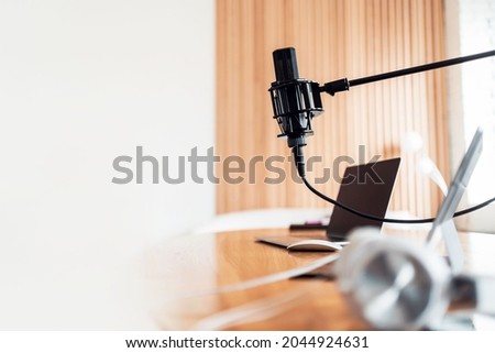 A microphone in the radio studio and computers on the table
