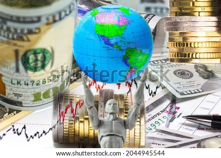 The concept of world trade and the dollar as a global world currency. The figure of a man holds a globe in his hands, in the background there are stock price charts and dollar bills, stacks of coins.