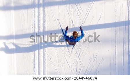 Skier cross-country skiing in snow forest. Winter competition, Aerial top view.