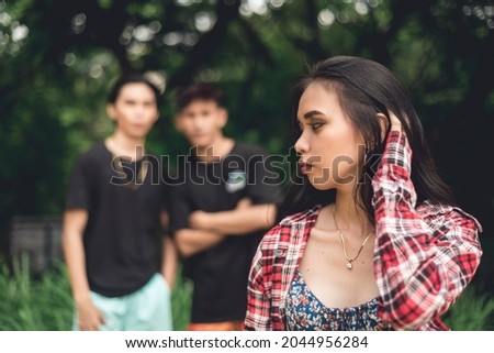 A nervous woman notices two men following her. Potentially dangerous stalkers trailing a woman walking by herself. Royalty-Free Stock Photo #2044956284