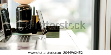 home studio work from home ideas concept,close up laptop technilody with black marbel vase home decorate items home stuidio with morning light window  with blur city background